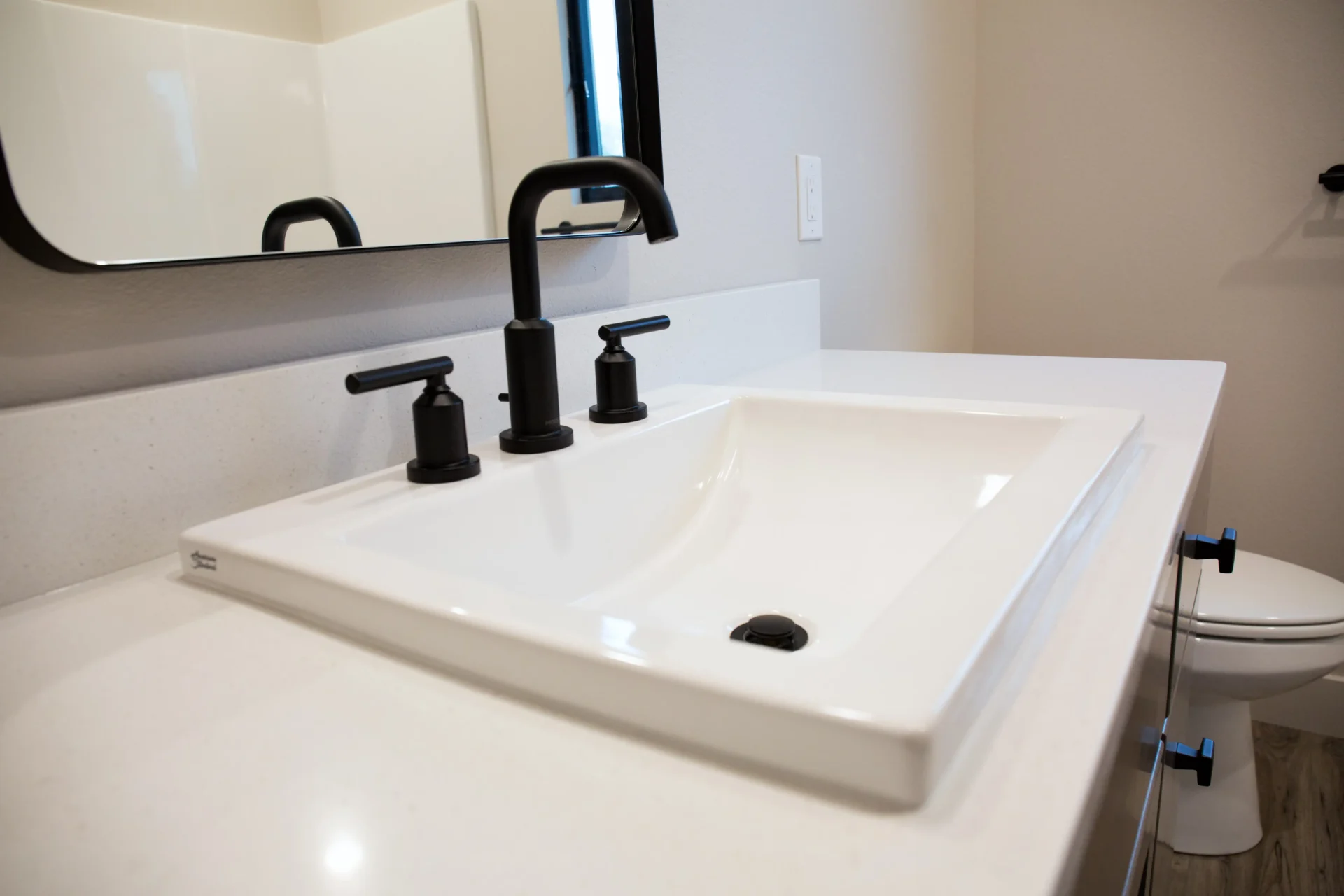 white marble sink and countertop with black faucet