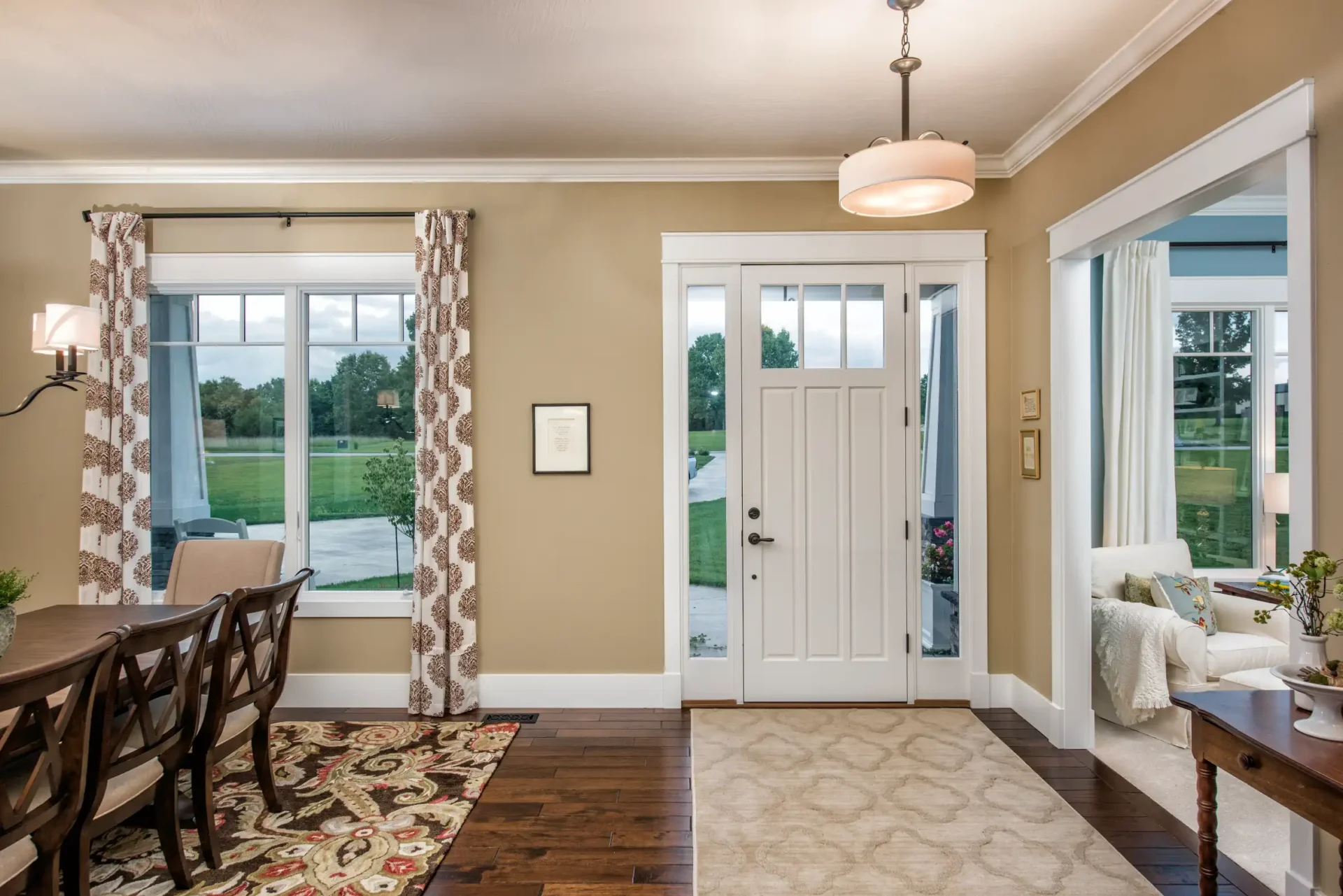 doorway with dining room and large windows with curtains