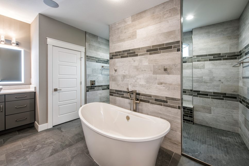 large bathroom with mirror and white tub with white door