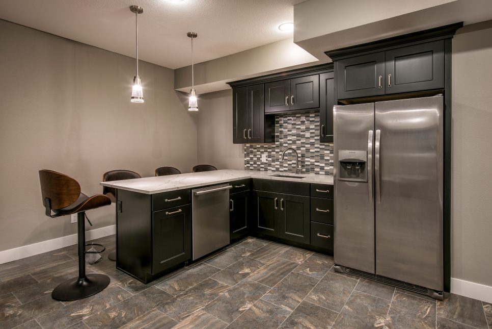 A kitchen with black furniture  