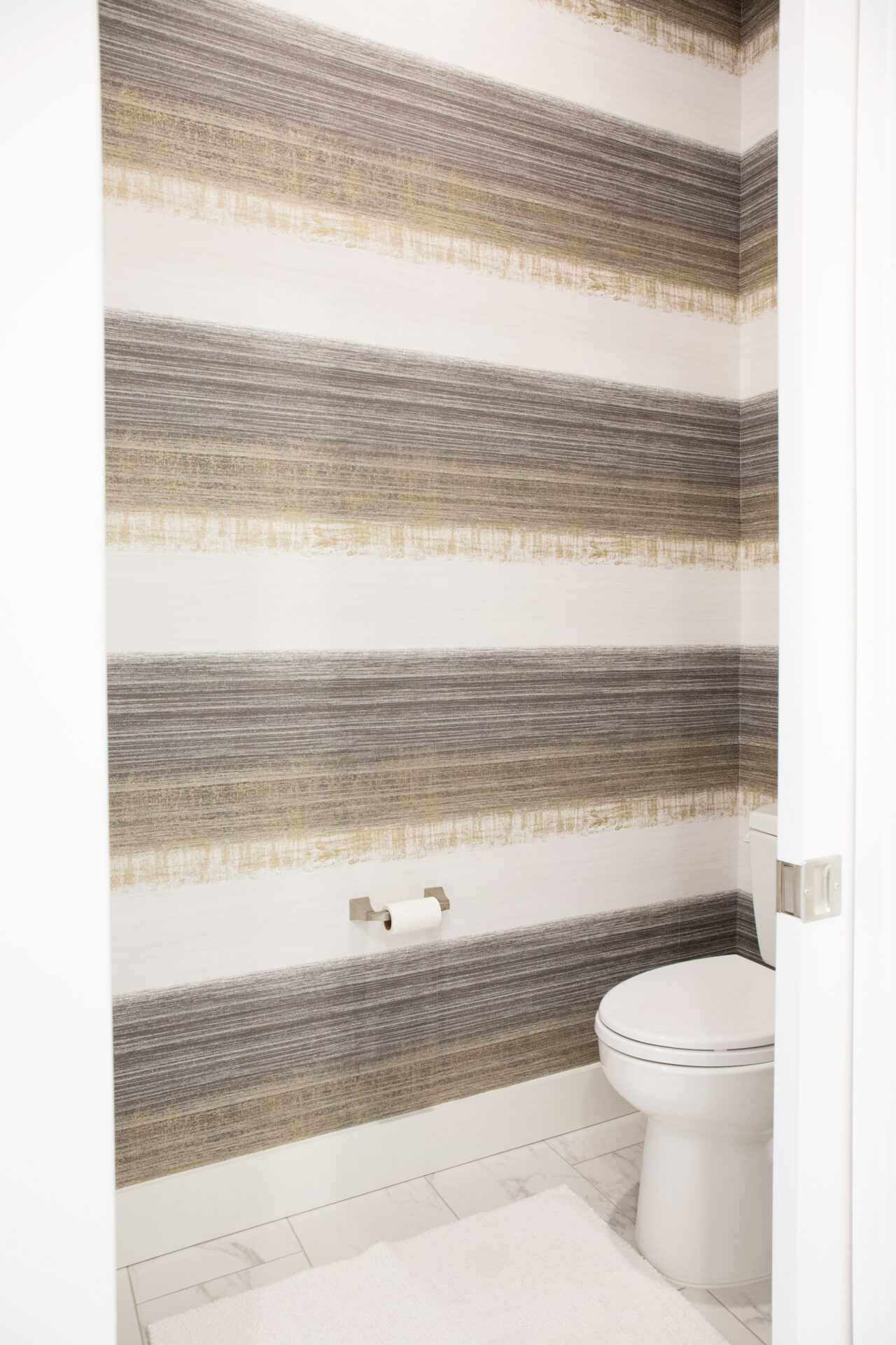 A bathroom with brown and white wallpaper
