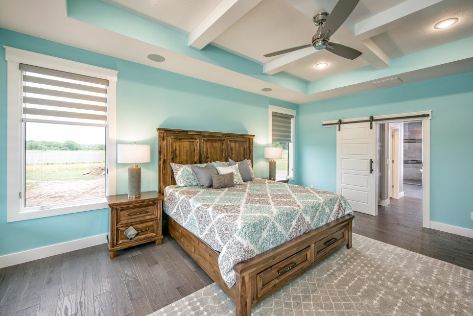 large bedroom painted robin’s egg blue with ceiling fan